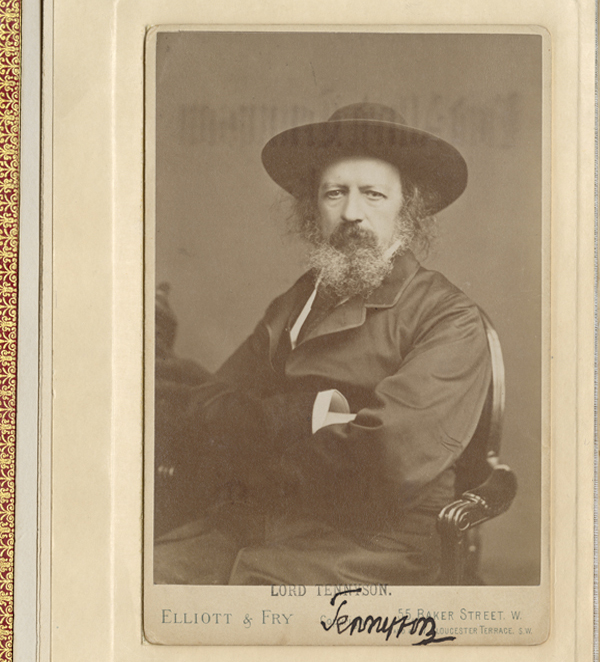 Signed cabinet card photograph inserted in a book, showing Alfred, Lord Tennyson seated in a formal pose, wearing a wide-brimmed hat and sporting a full beard.